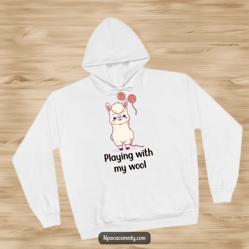 Funny Kawaii Alpaca Hoodie featuring a playful alpaca tossing colorful yarn, offering cozy comfort and delightful humor.